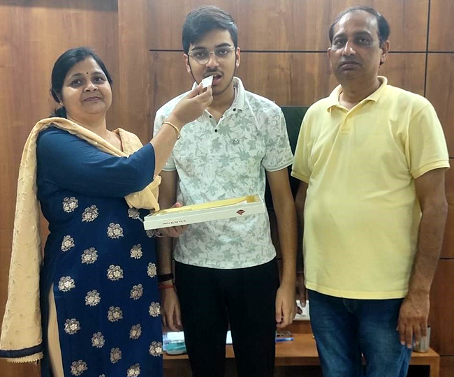 जिला टाप करने पर ध्रुव को मिठाई खिलाते पिता नीरज और मां। सौ. स्वयं।